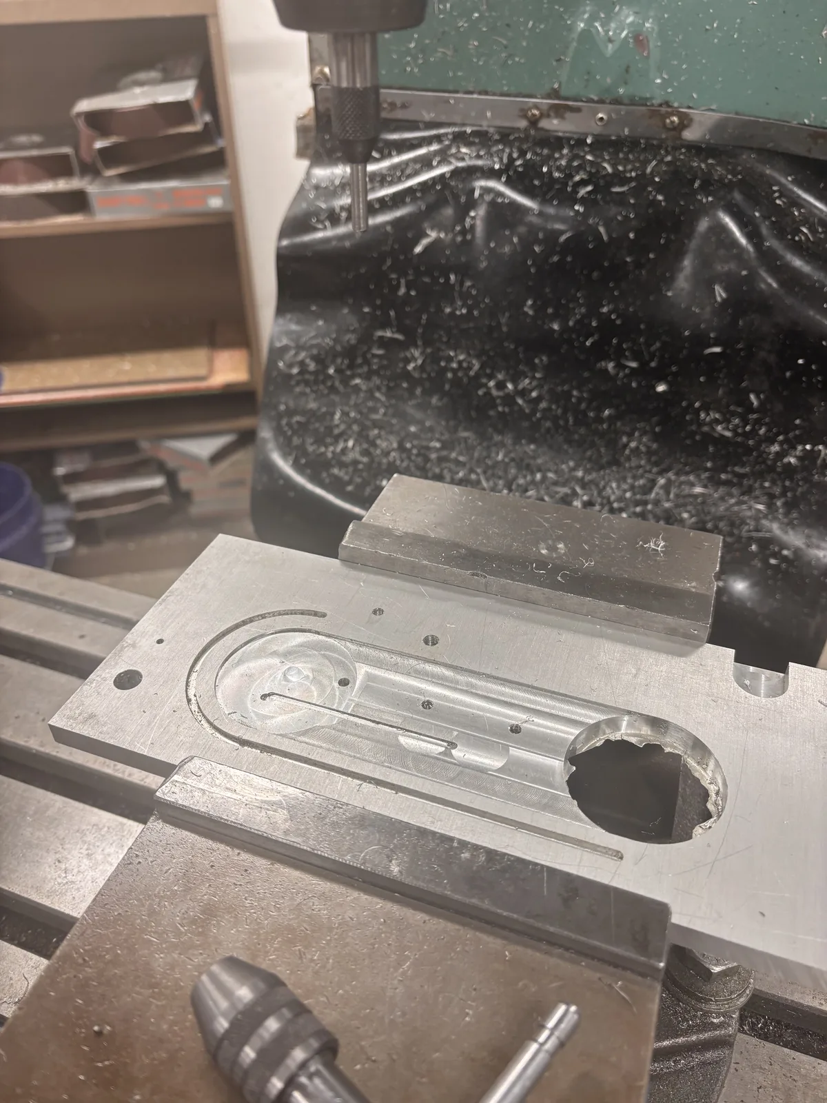 An aluminum enclosure panel clamped on the mill, with a milled pocket finished